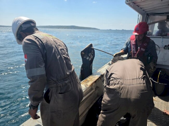 Petugas Ditpolairud Polda NTT bersama tim gabungan membersihkan tumpahan minyak di perairan Pulau Semau yang diduga berasal dari kebocoran bangkai KM Kuala Emas.